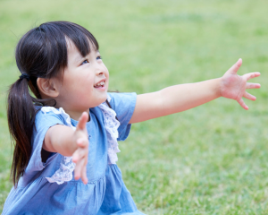 手を広げる笑顔の女児