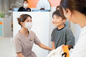 受付でスタッフと笑顔で話すお子さま
