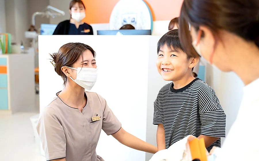 キッズクラブの定期検診で歯科衛生士と笑顔で話す子ども