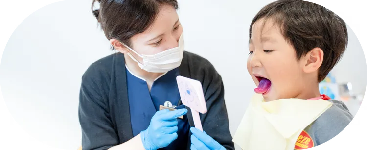 子どもが大きくお口を開けて歯科衛生士に見せている様子｜刈谷市のこども歯科キッズデンタルステーション