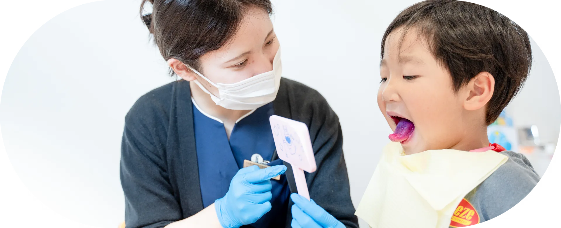子どもが大きくお口を開けて歯科衛生士に見せている様子｜刈谷市のこども歯科キッズデンタルステーション